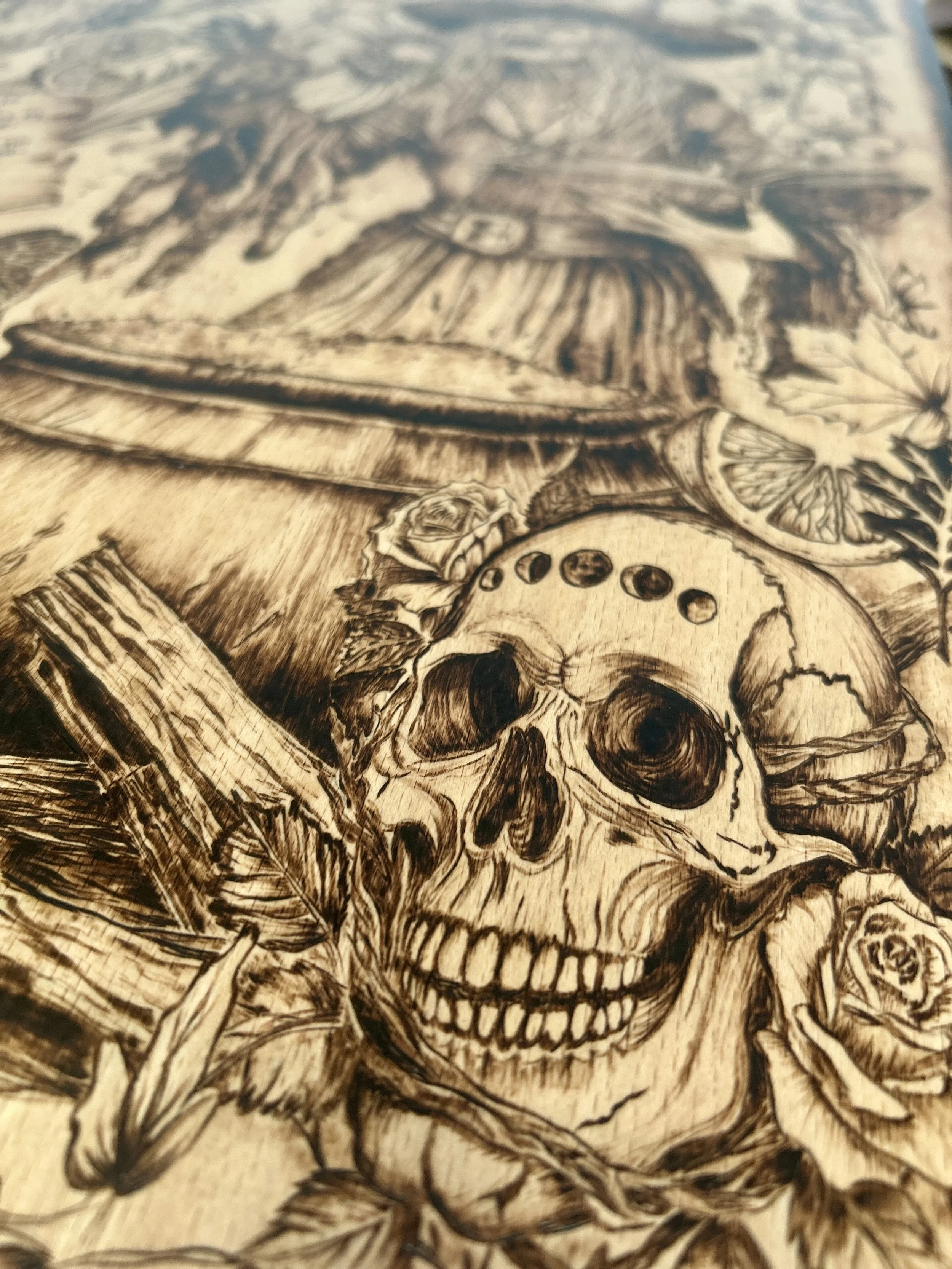 Focus on a detailed human skull and fire logs at the base of the cauldron, featuring intricate bone texture and dark shading.