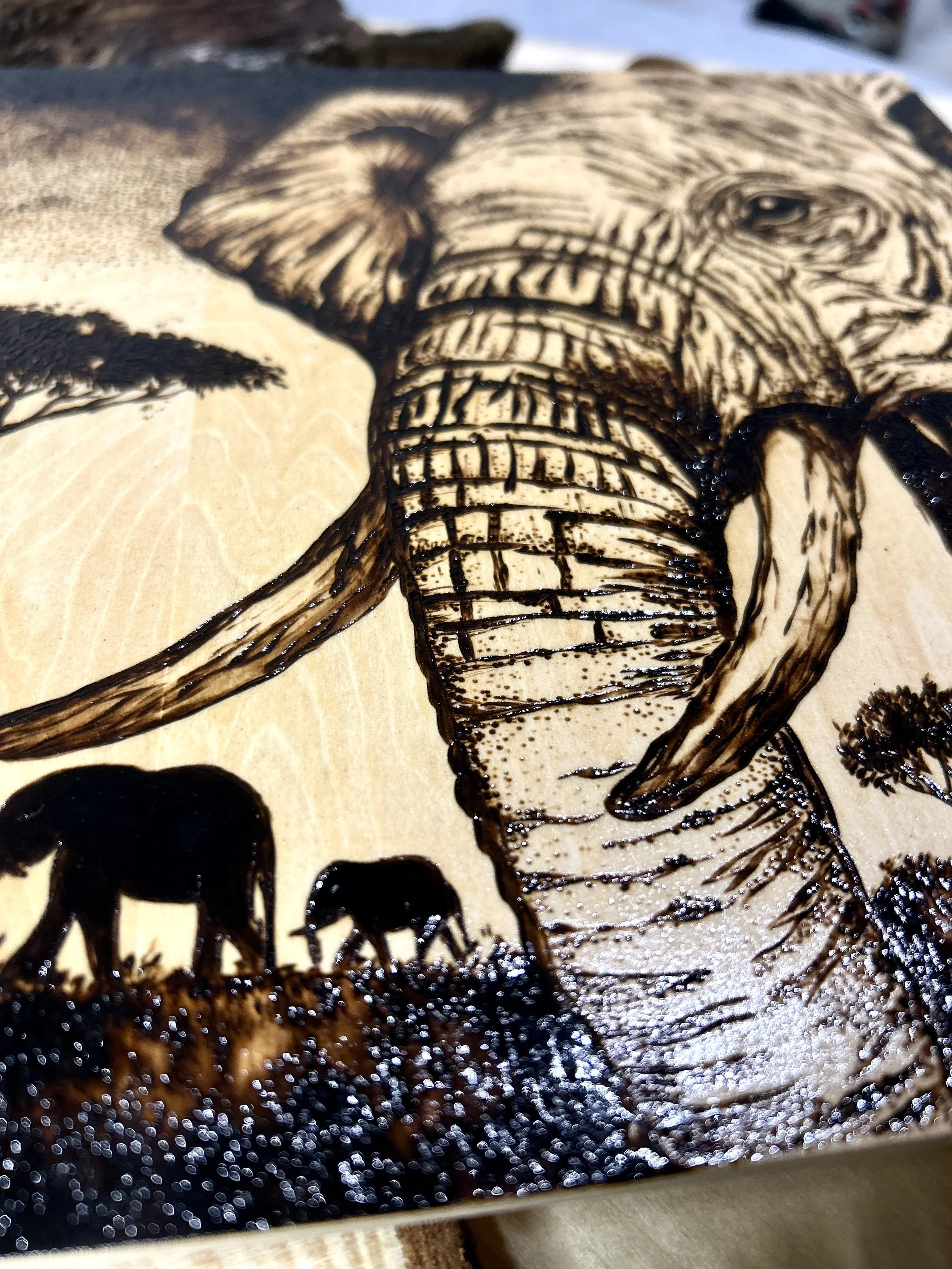 Collection of wood-burned pyrography artworks showcasing handcrafted fantasy art in unique, artisan, one-of-a-kind designs and decor, featuring detailed Savanna Reverie elephant scenes on natural wood