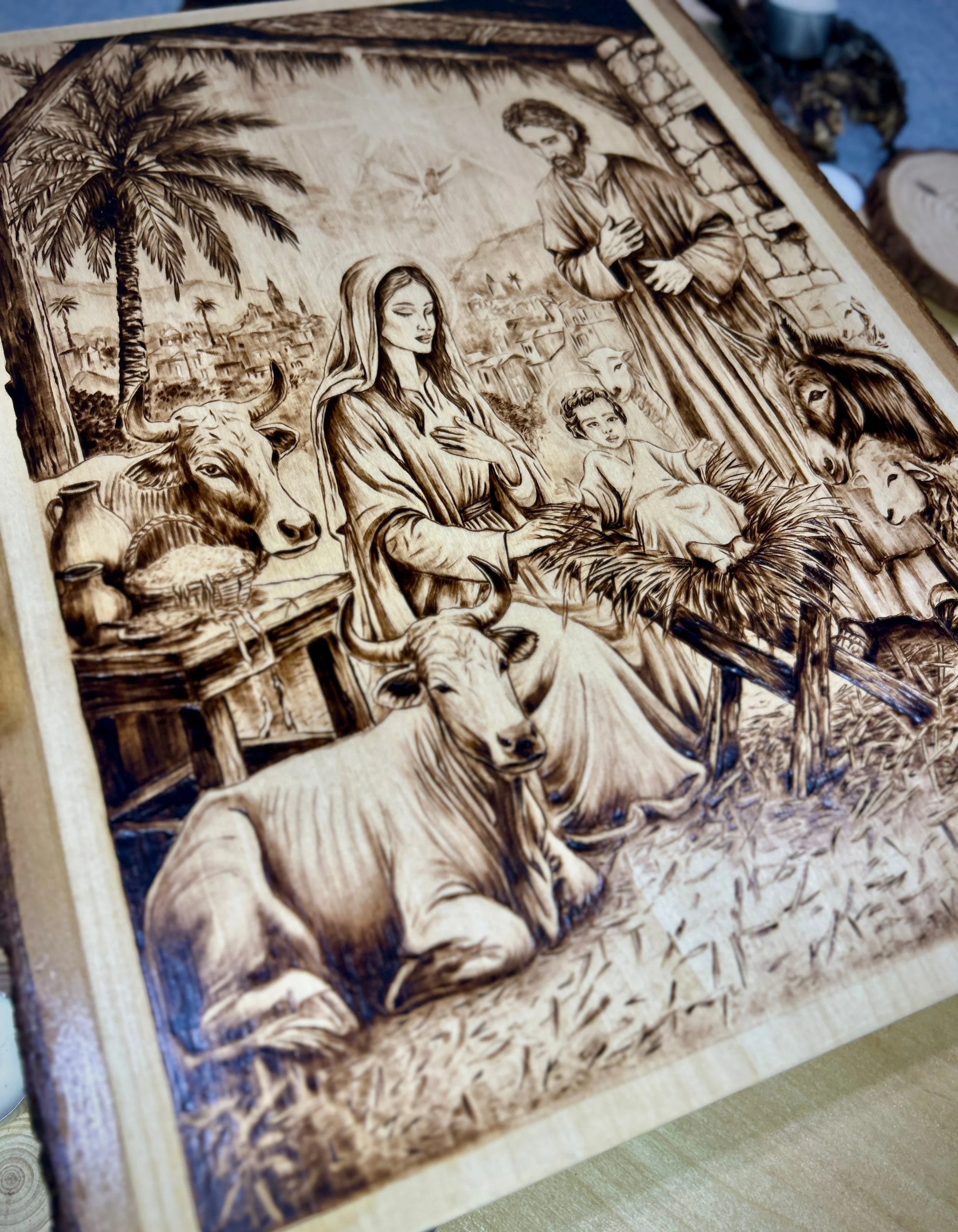 Close-up of central nativity figures in Stable Of Grace pyrography artwork on solid hardwood.