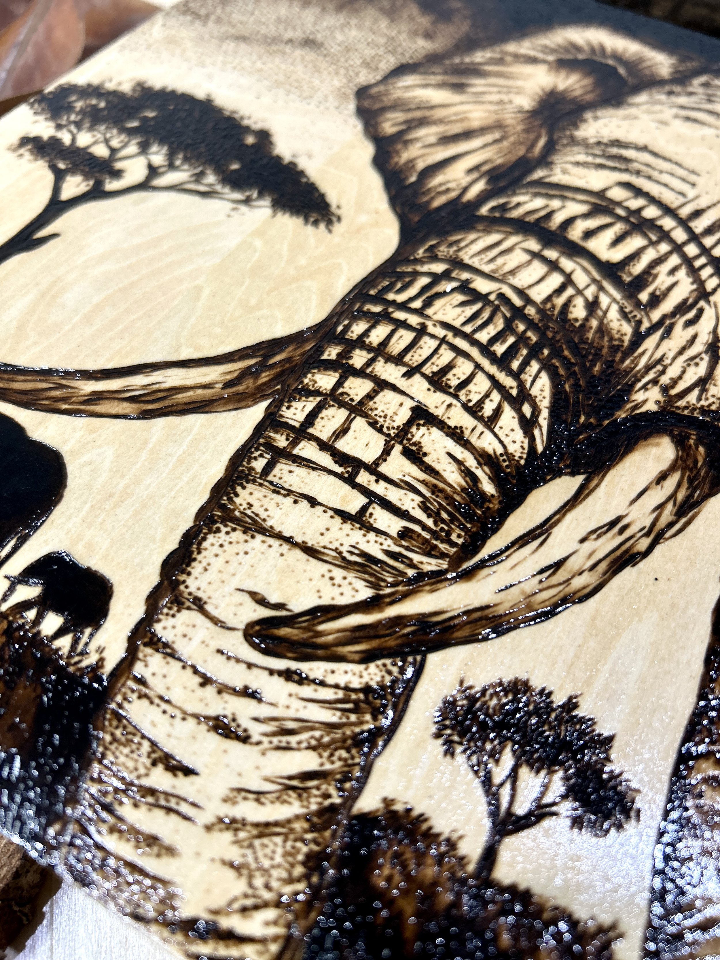 Collection of wood-burned pyrography artworks showcasing handcrafted fantasy art in unique, artisan, one-of-a-kind designs and decor, featuring detailed Savanna Reverie elephant scenes on natural wood