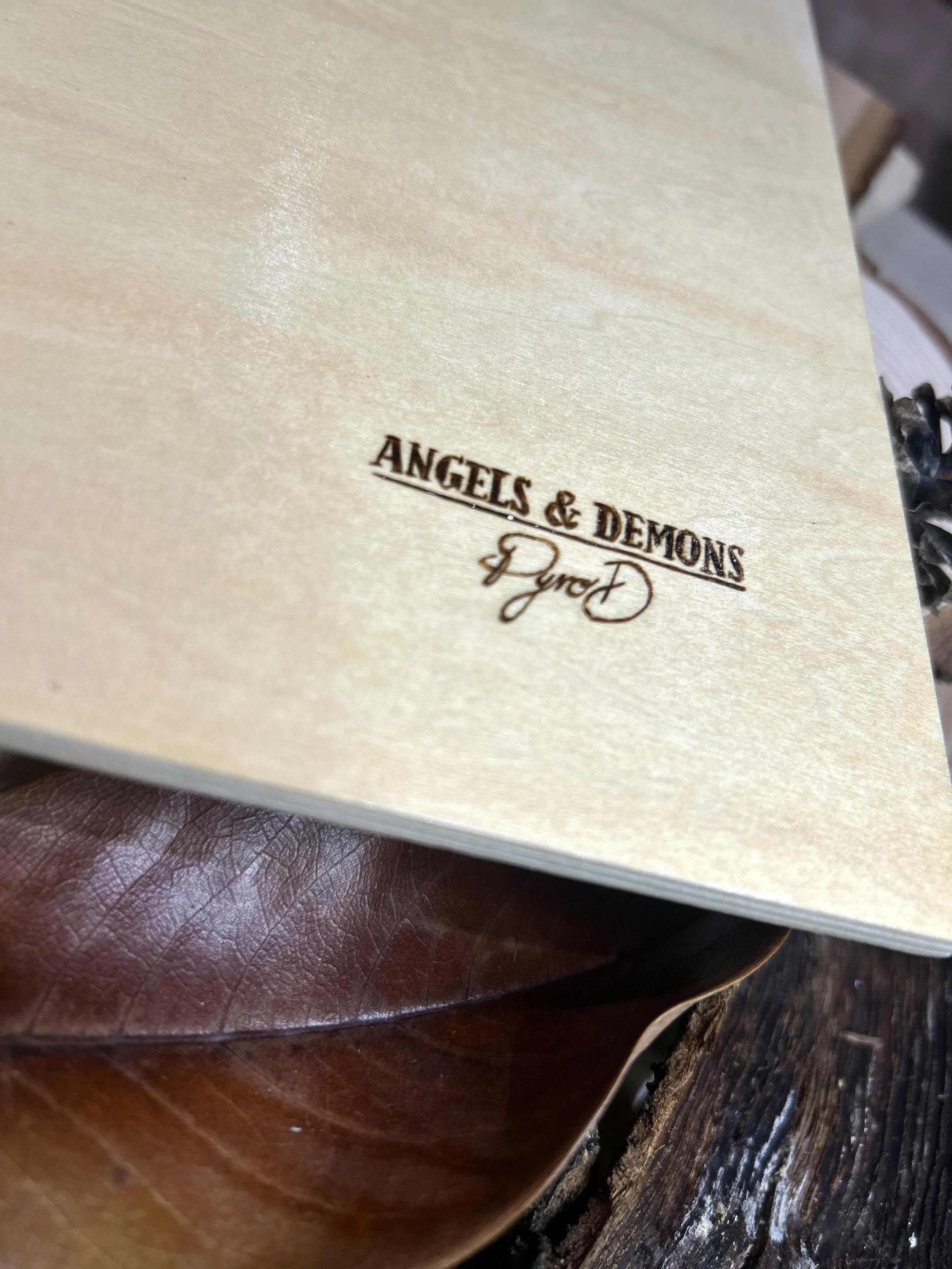 Collection of wood-burned pyrography artworks featuring angels and demons, showcasing handcrafted fantasy art in unique, artisan, one-of-a-kind designs and decor