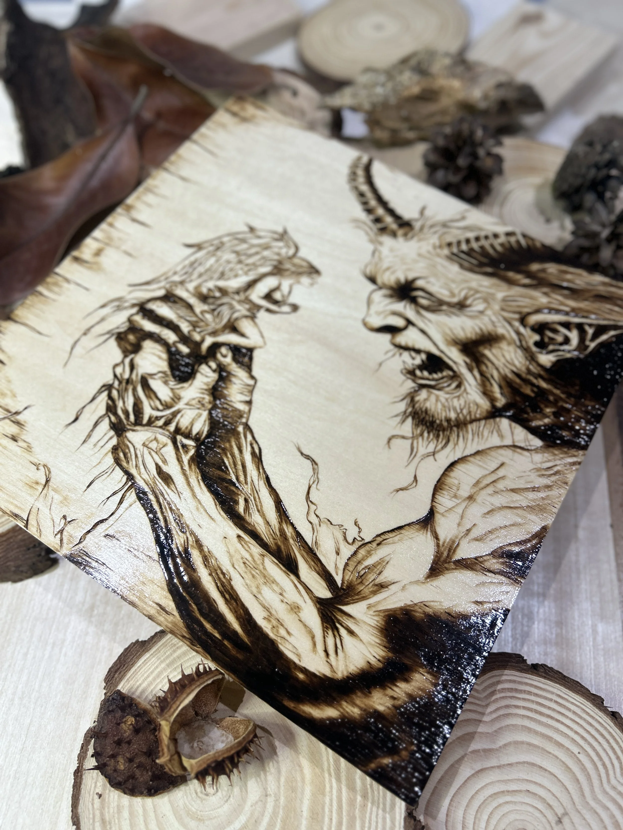 Collection of wood-burned pyrography artworks featuring angels and demons, showcasing handcrafted fantasy art in unique, artisan, one-of-a-kind designs and decor