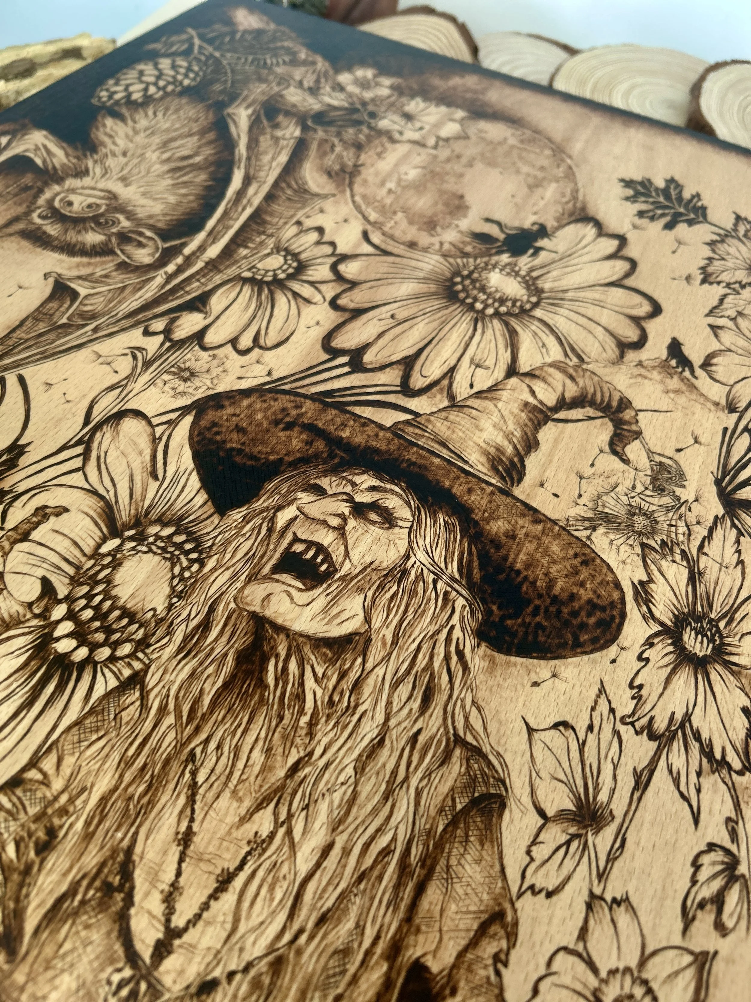 Wider shot of the witch figure surrounded by large daisy-like flowers and a butterfly, highlighting the botanical-gothic fusion.