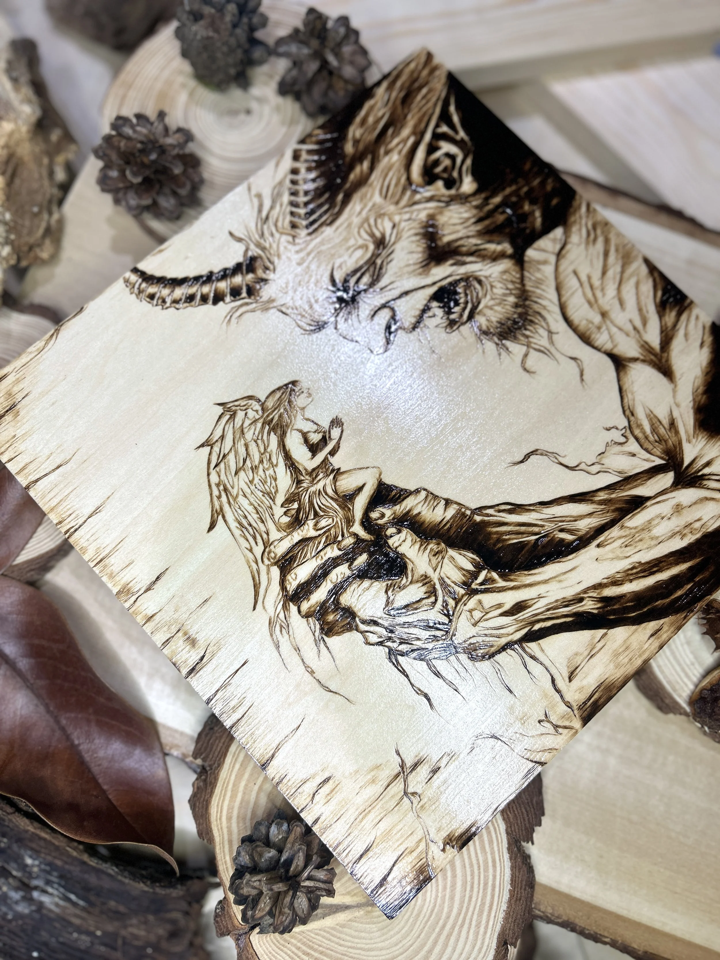Collection of wood-burned pyrography artworks featuring angels and demons, showcasing handcrafted fantasy art in unique, artisan, one-of-a-kind designs and decor