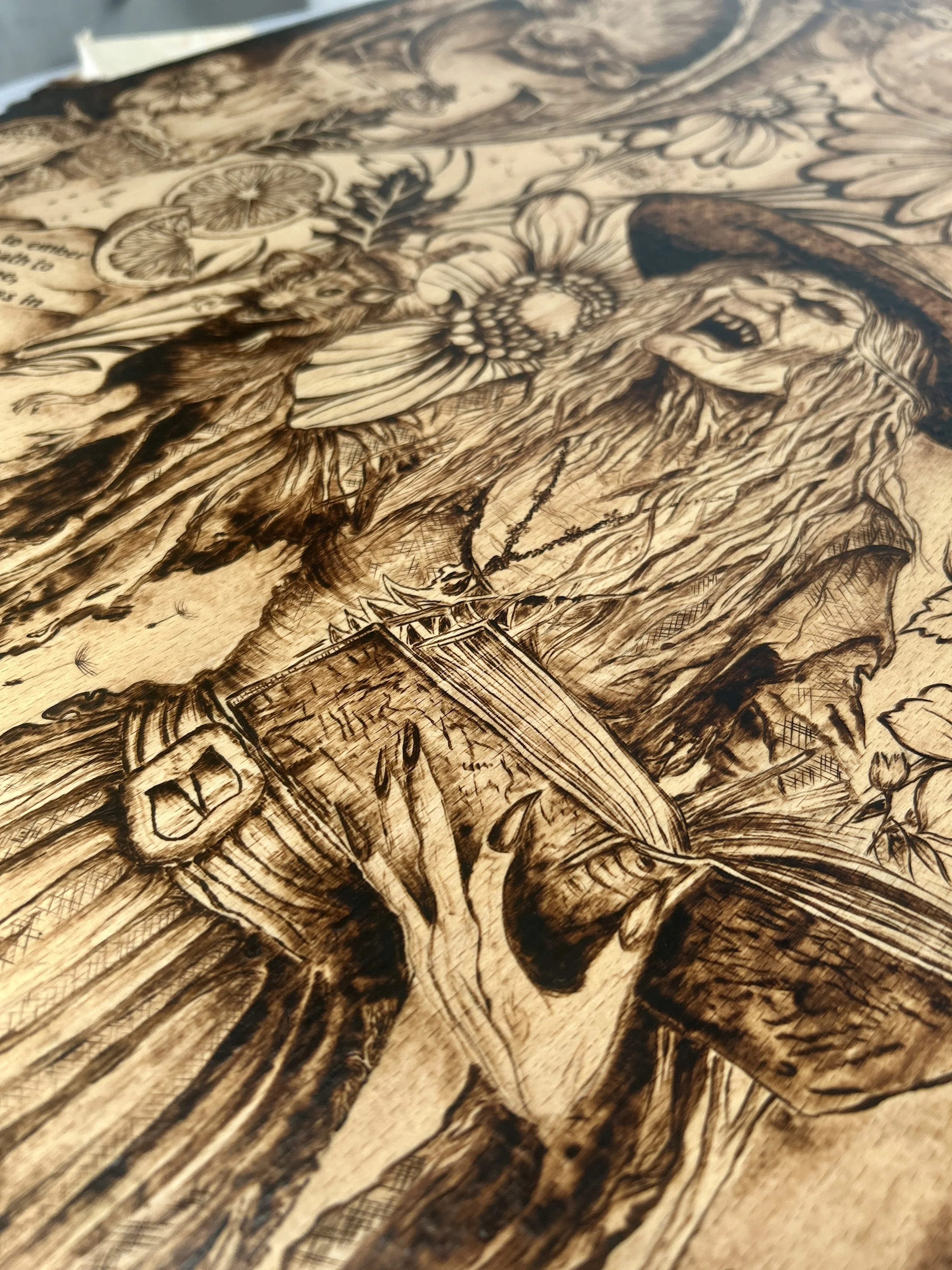 Detailed view of the witch’s belt and spellbook, showcasing the intricate line work and dark burned shadows on the wood.
