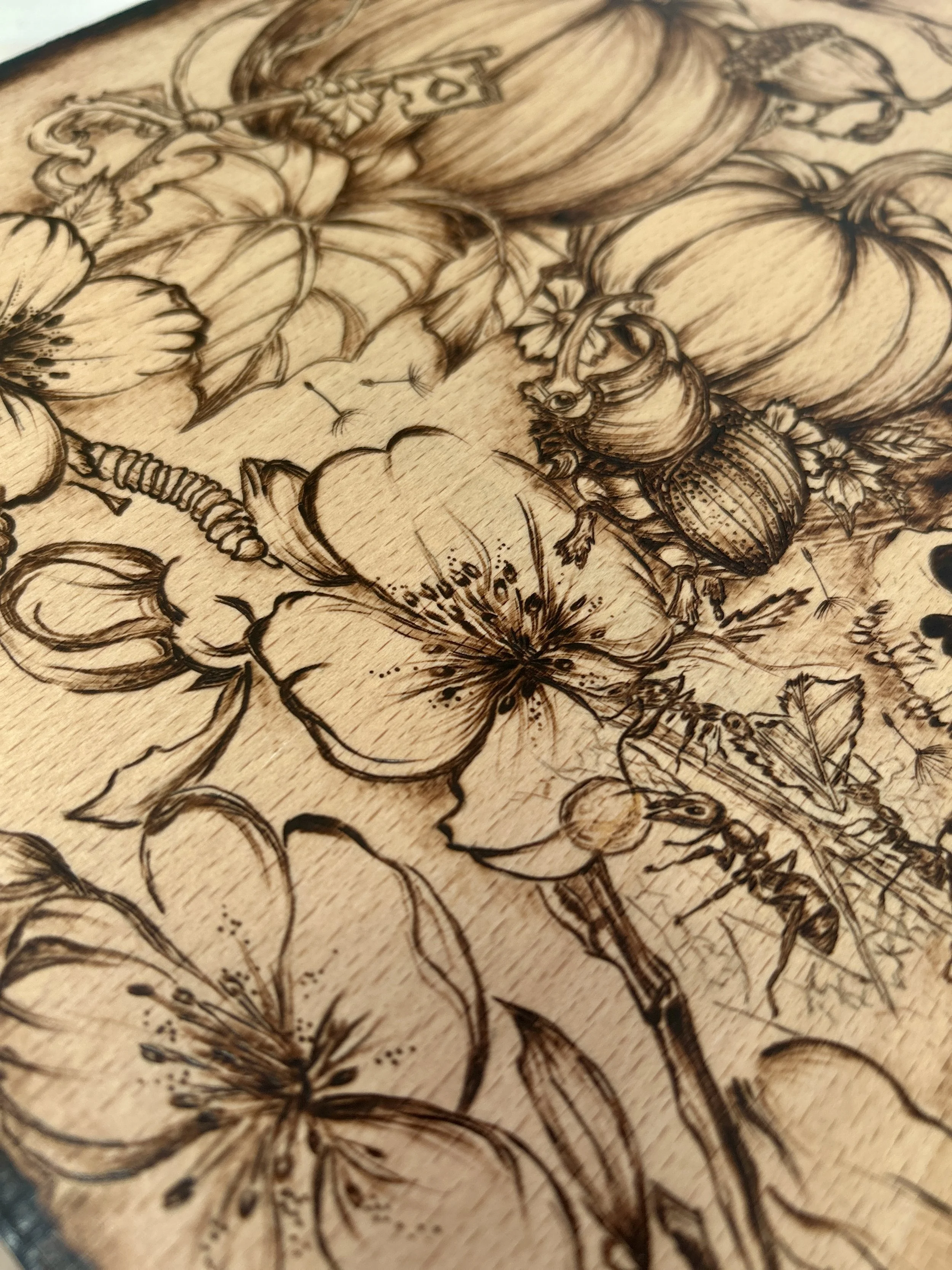 Corner view of the bottom-right artwork, displaying a cluster of pumpkins, small skulls, and intricate floral patterns.