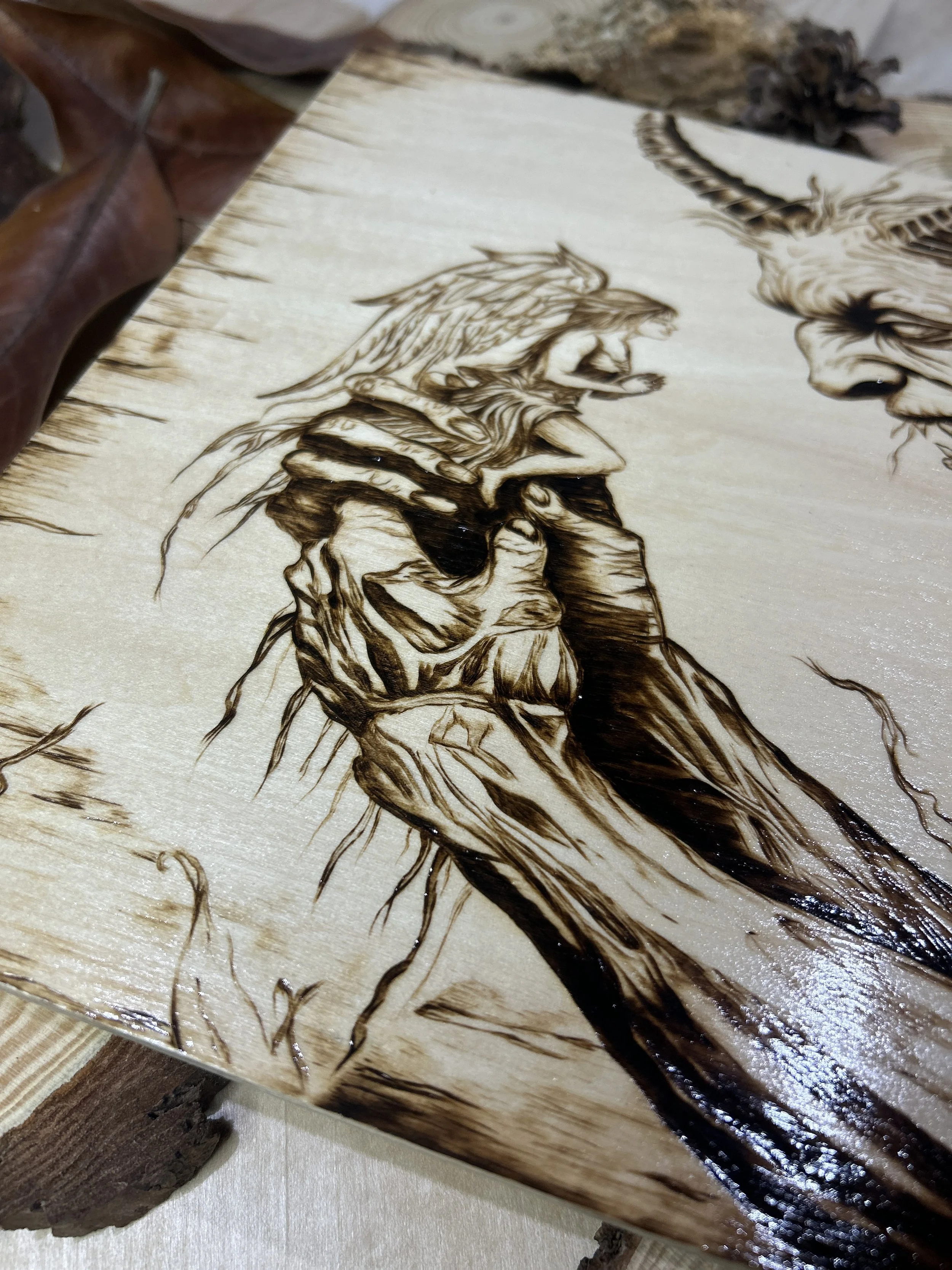 Collection of wood-burned pyrography artworks featuring angels and demons, showcasing handcrafted fantasy art in unique, artisan, one-of-a-kind designs and decor