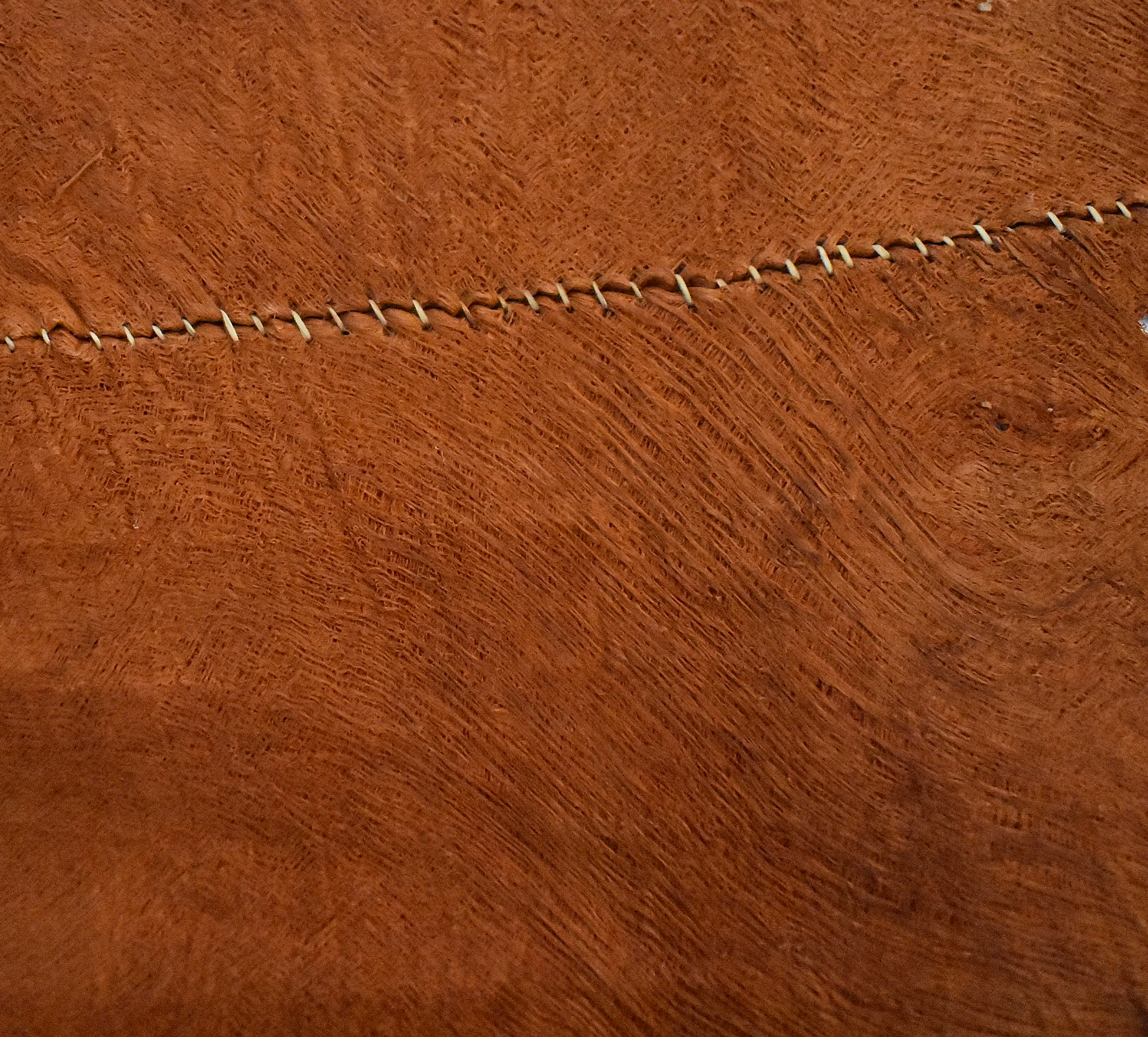 Larger imperfections are sewn up to prevent propagation. These are left on upon finishing and act as a distinguisher between sheets.