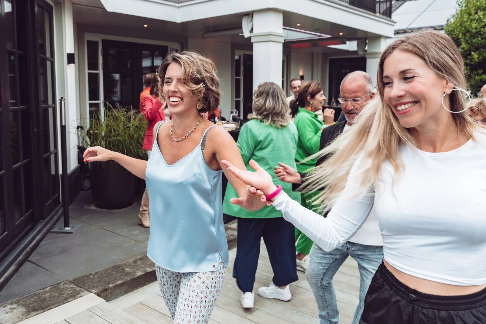 People dancing and having fun at an outdoor party or gathering on a patio or deck.