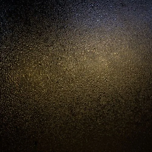 Tummansininen, karhea ja kostean näköinen metallipinta, jota peittää pieniä vesipisaroita