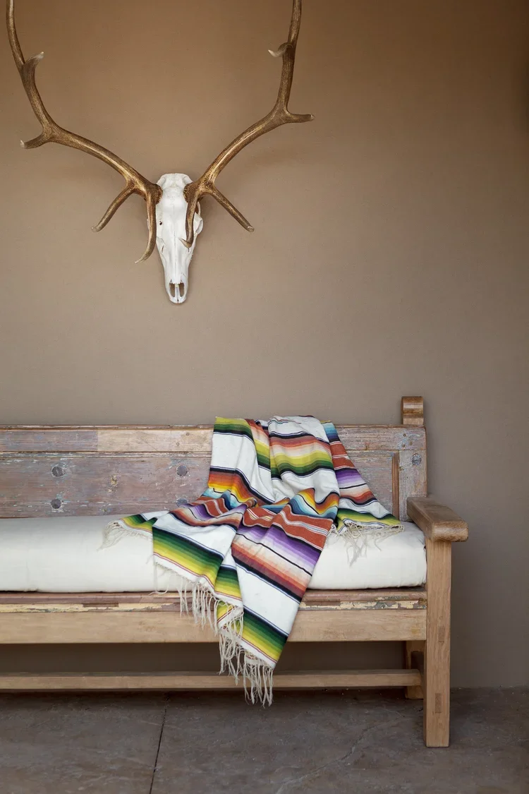 Rustic Bench with Antler Wall Decor and Colorful Blankets