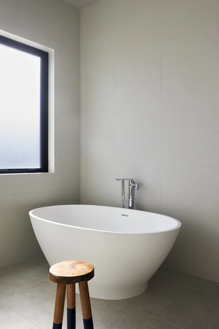 Minimalist Bathroom with Freestanding Tub and Wooden Stool