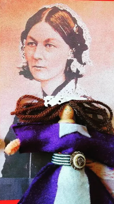 A vintage illustration of a woman with dark hair styled in loose waves, wearing a dark dress with a white lace collar, and an actual handmade doll dressed in a purple dress with brown yarn hair, placed in front of the illustration.