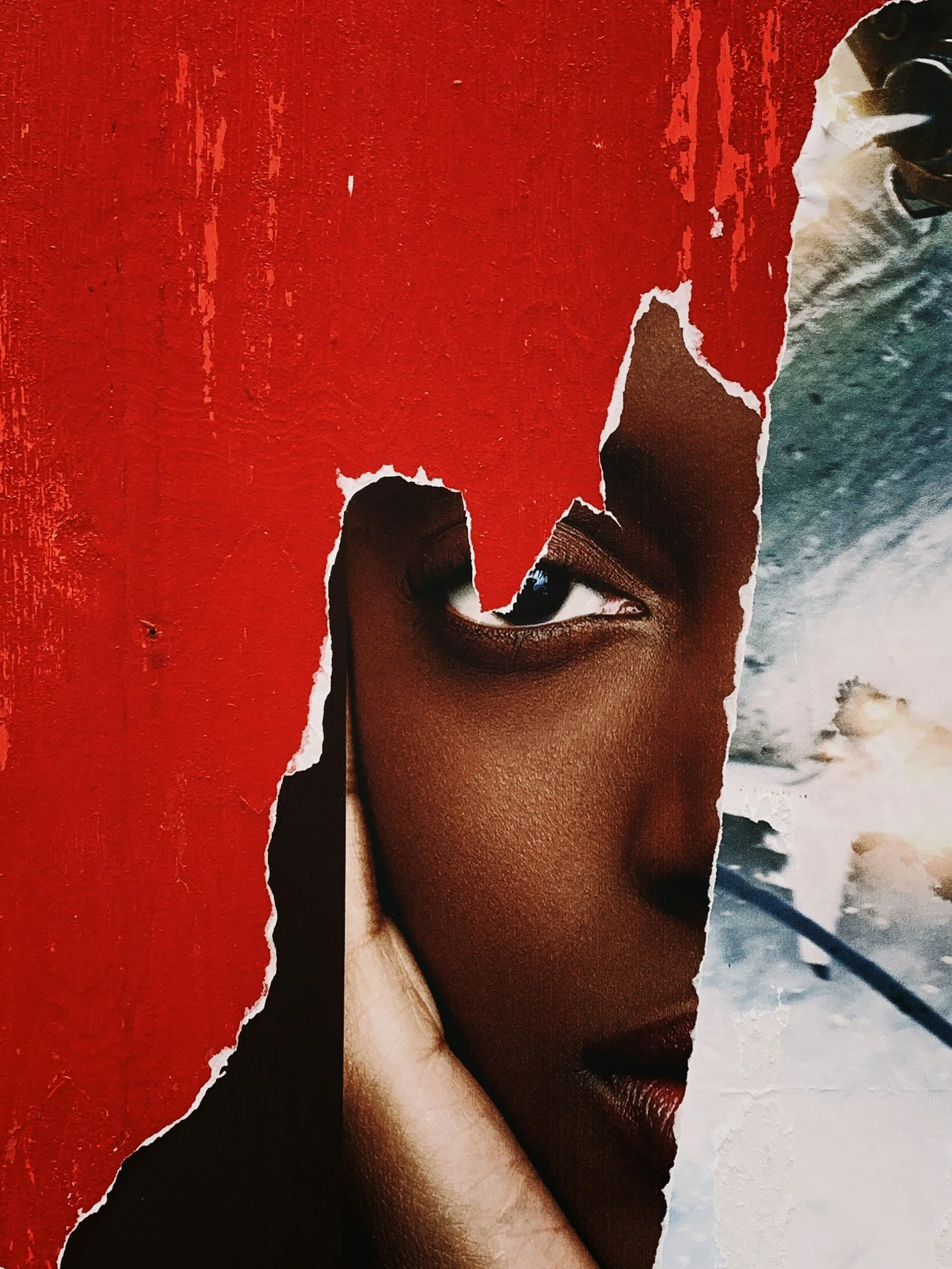 A collage of torn magazine paper revealing a woman's face, with a red textured background and a beach scene on the right.