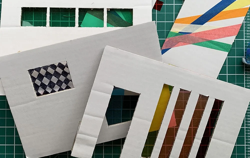 Assorted paper craft templates with various cutouts and colorful patterned papers on a green cutting mat.