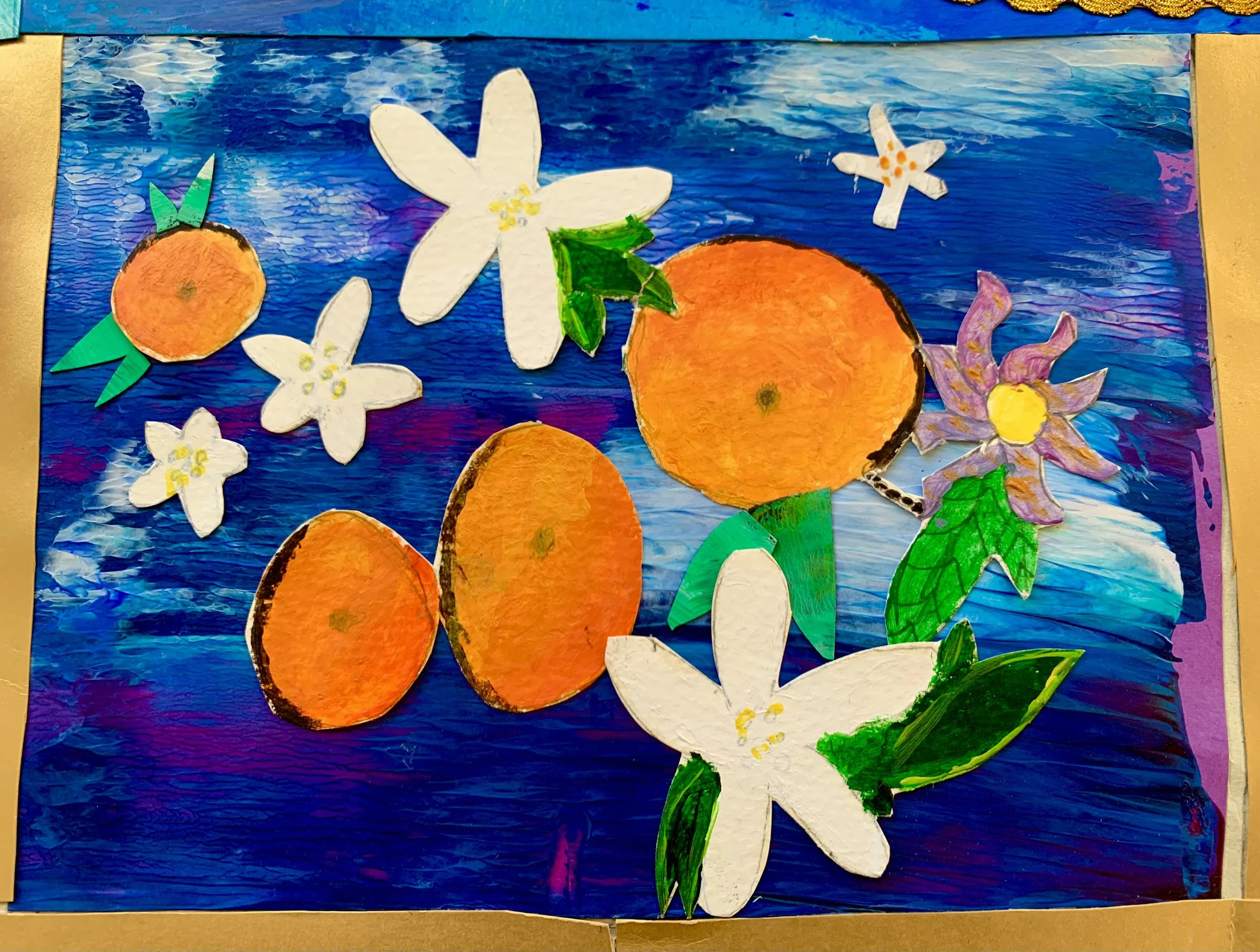 Colorful collage of oranges, white flowers, and green leaves on a painted blue background.