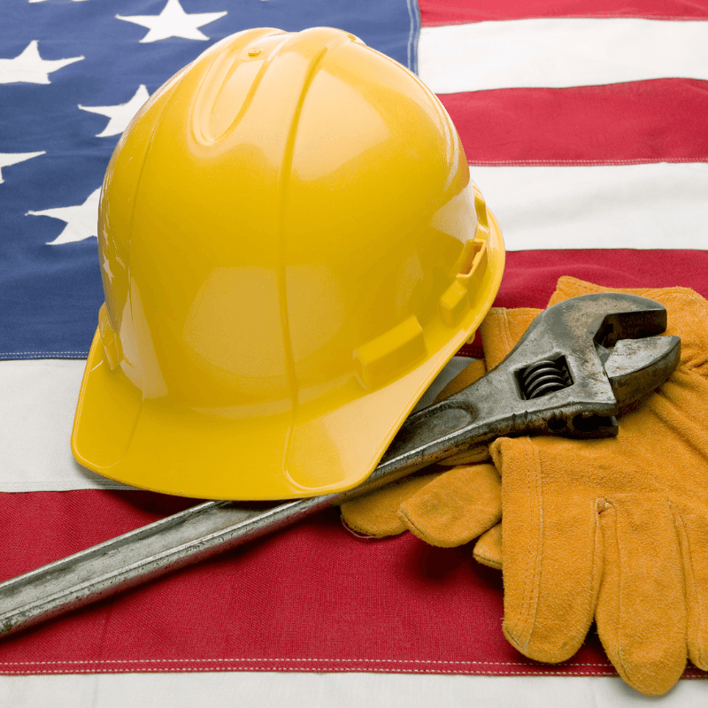 image of American flag with hard hat and wrench for South Africans exploring refugee program and need jobs
