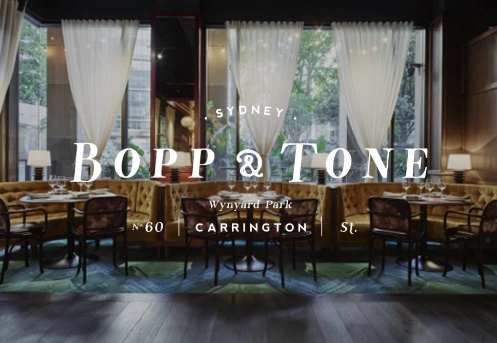 Interior of a restaurant with large windows, white curtains, and a mix of chairs and tables, with text overlay about Sydney and a restaurant name.