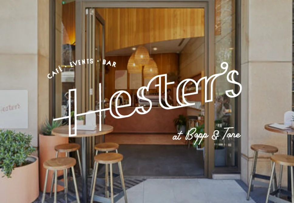 Entrance of a cafe called 'Lester's at Bopp & Tore' with outdoor seating and a wooden interior visible through glass doors.