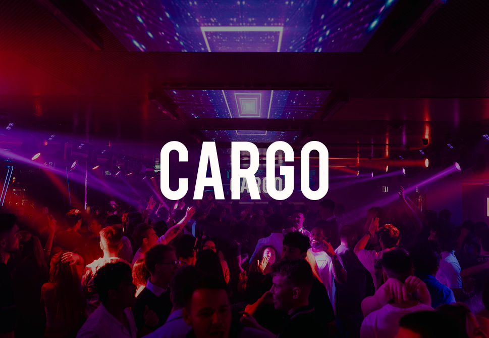 Crowd of people dancing and socializing at a nightclub with colorful lights and laser effects, with the word 'CARGO' prominently displayed in the center.