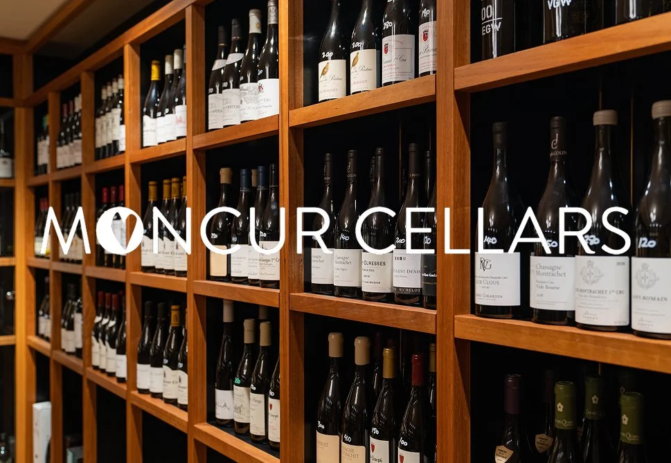 Wooden wine cellar shelves filled with assorted wine bottles.