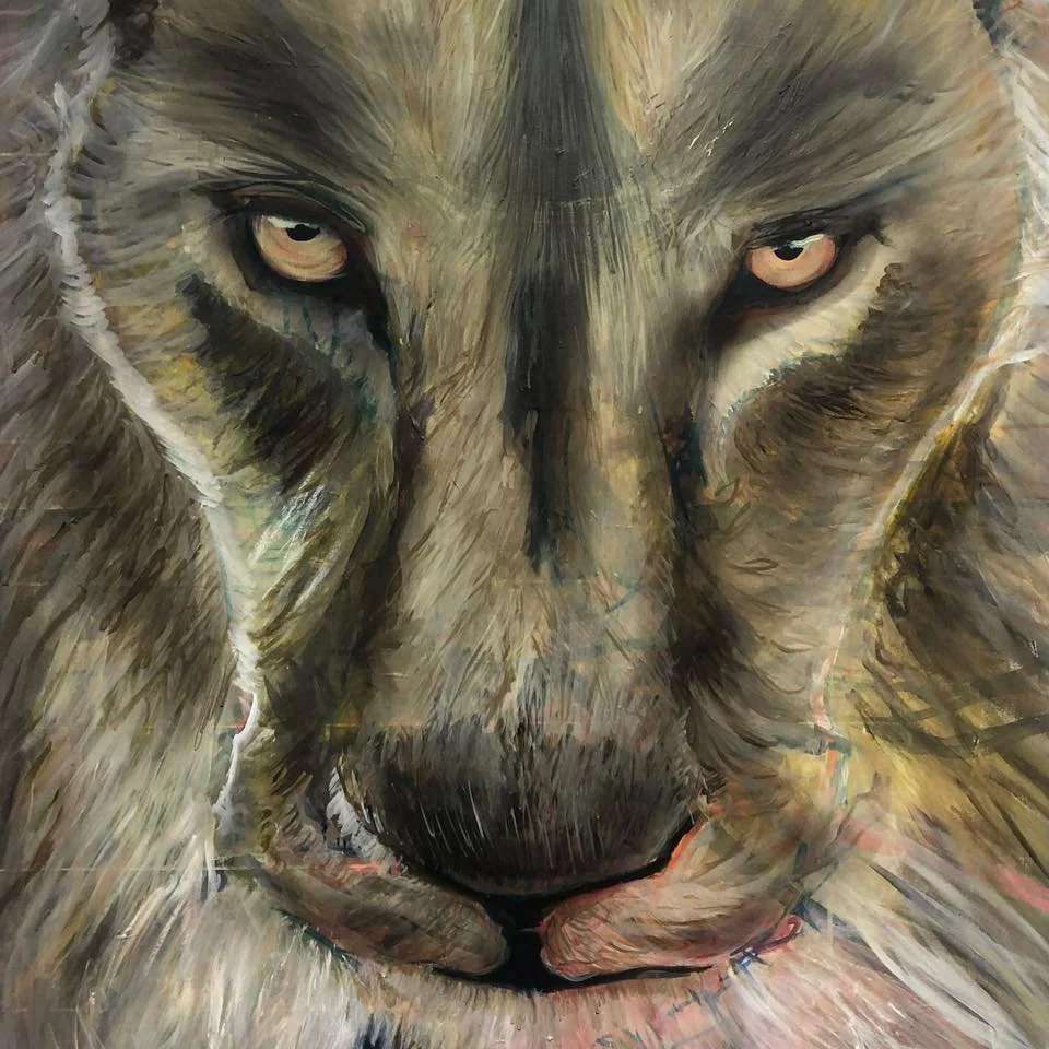 Close-up of a painting of a wolf's face with piercing eyes.