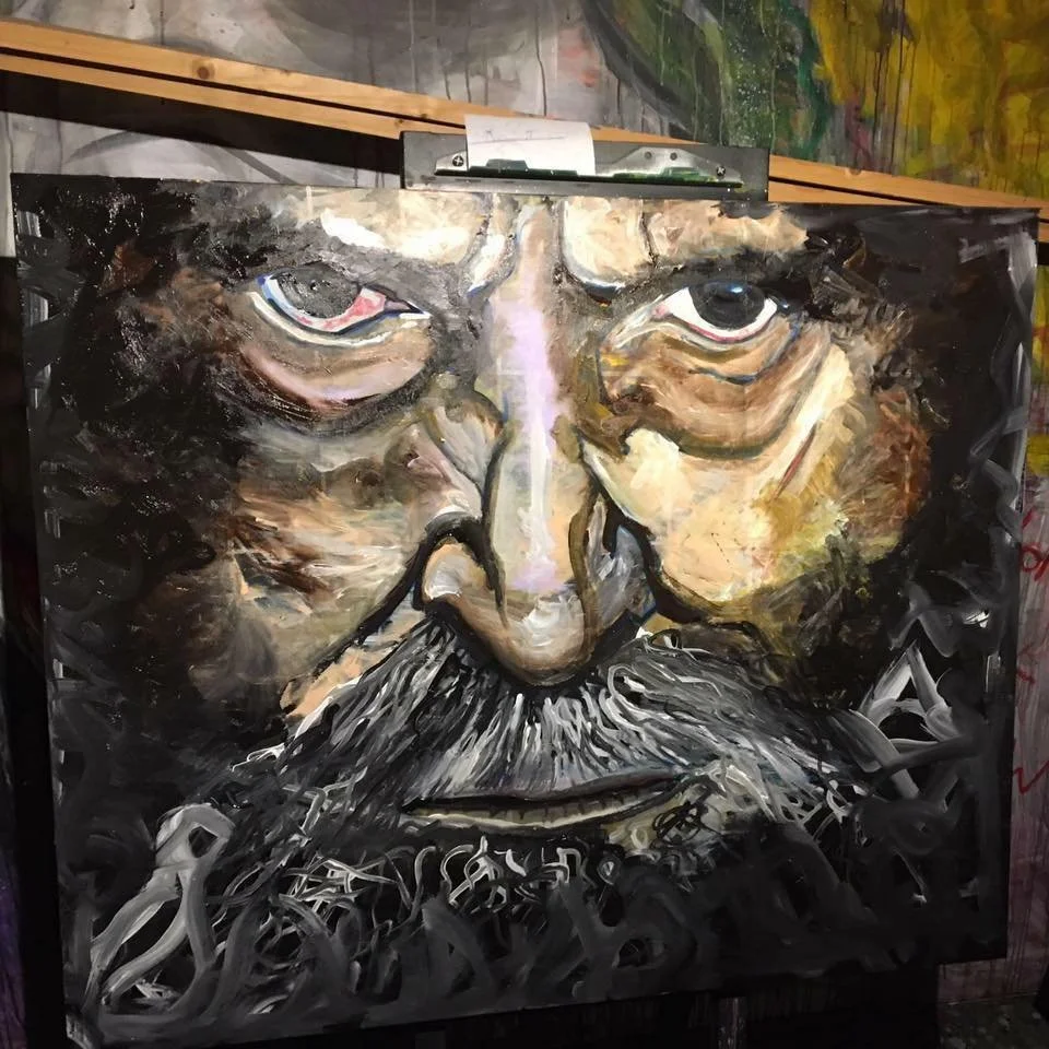 A painting of an elderly man with glasses, a mustache, and a beard, painted in an abstract style with bold brushstrokes and earthy colors.