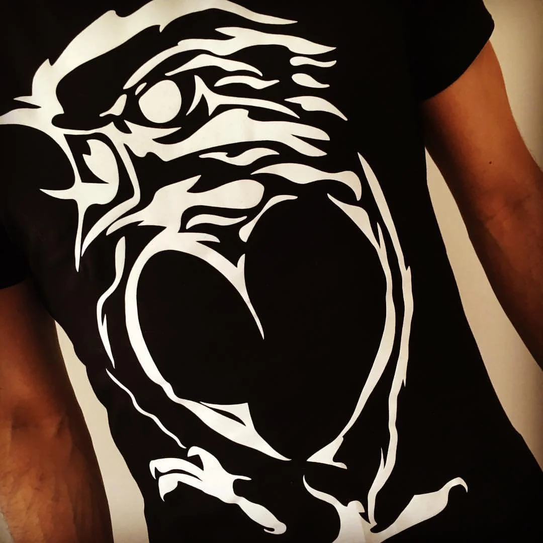 A person wearing a black T-shirt with a white graphic print of Darth Vader's face and helmet from Star Wars.