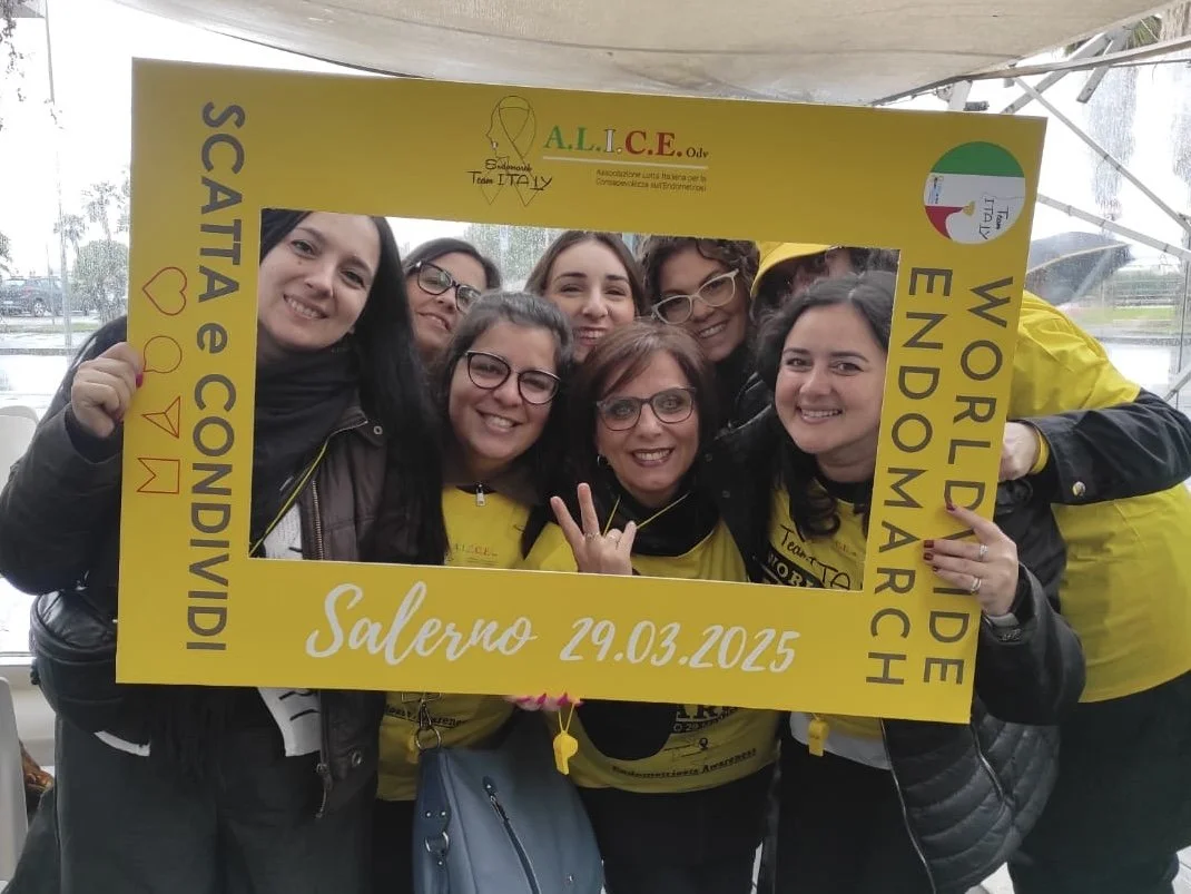 Gruppo di persone sorridenti con cornice gialla con scritto 'WORLIDWIDE ENDO MARCH' e dettagli sulla manifestazione a Salerno il 29 marzo 2015.