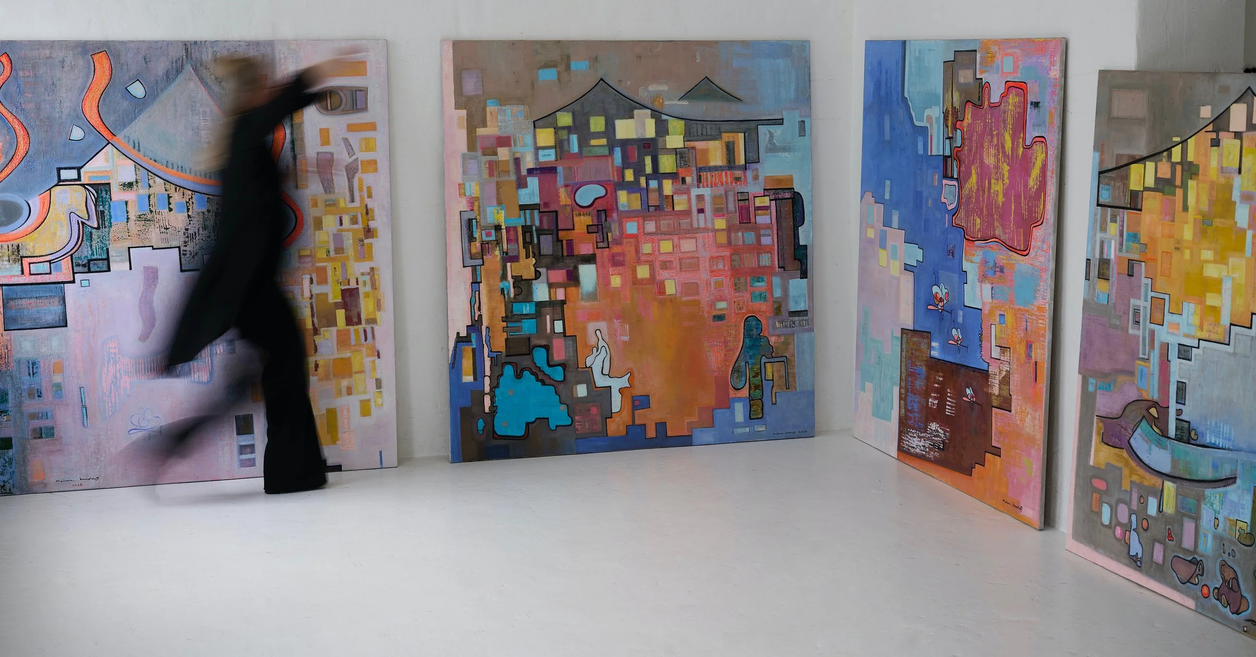 A person moving in front of large colorful abstract paintings on gallery walls.
