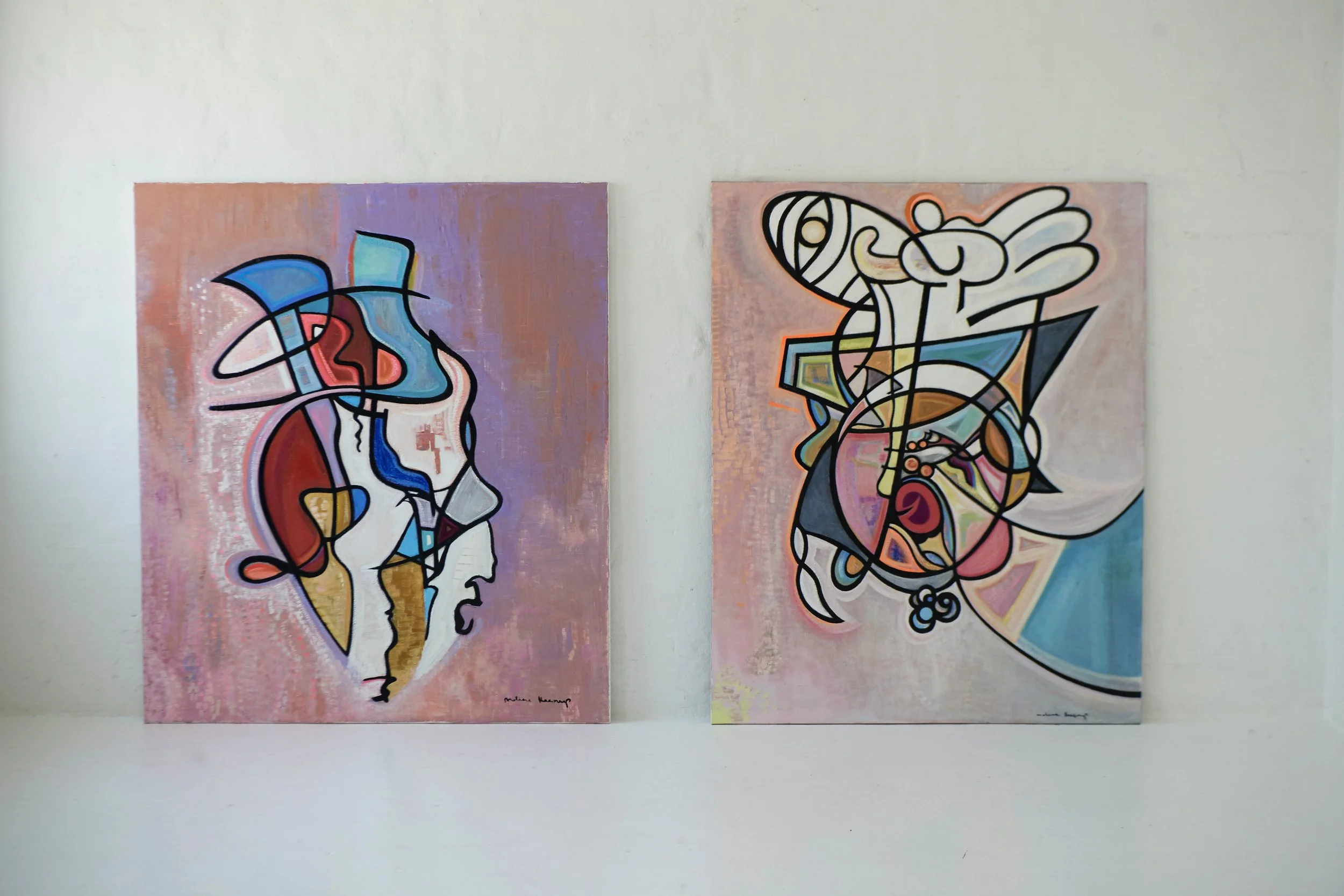 Two abstract paintings with colorful lines and shapes on a white gallery wall.