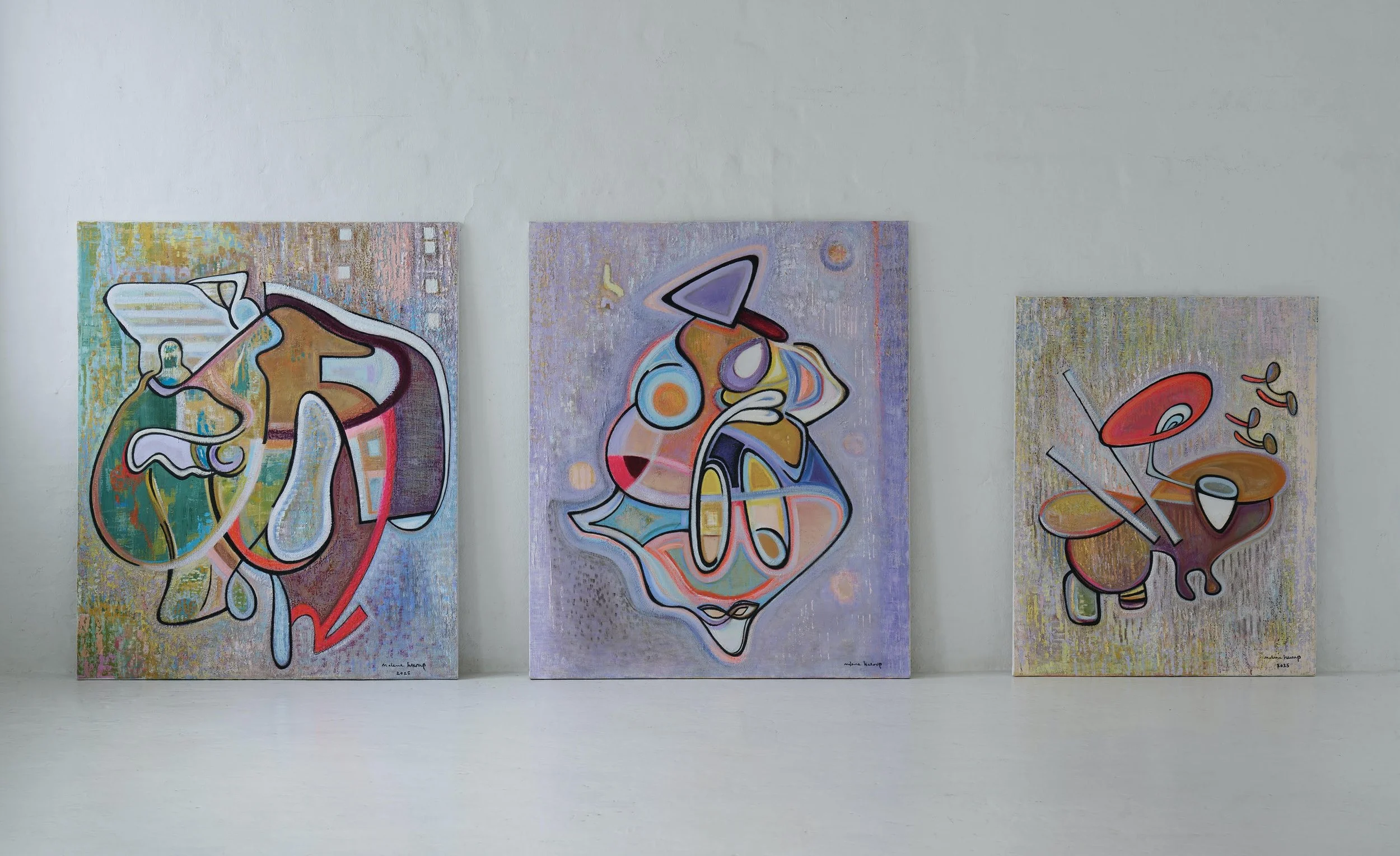 Three abstract paintings with colorful, fluid shapes displayed against a white gallery wall.