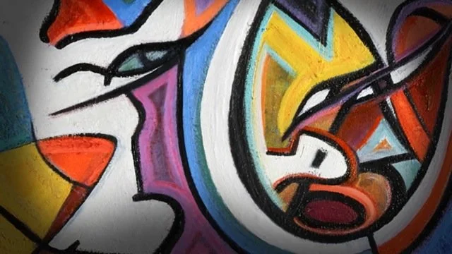 A colorful abstract mural with various shapes, lines, and colors including yellow, orange, purple, blue, black, and pink.