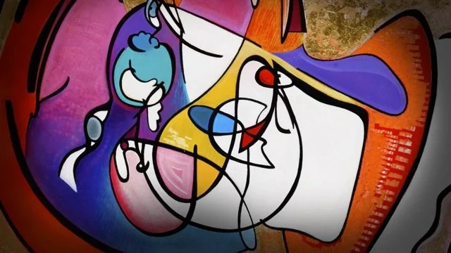 Colorful graffiti mural featuring abstract, cartoon-like character with vibrant blue, purple, yellow, and red colors.