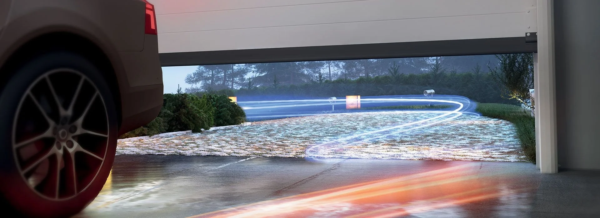 Blurred view of a car driving into a garage, with light trails captured in a long exposure, showing a driveway, quality landscaping, and trees in the background.