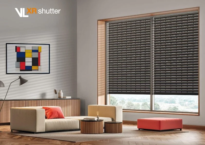 Modern living room with beige sofa, coral throw pillow, rectangular window with black horizontal blinds, abstract wall art, wooden sideboard, floor lamp, small round coffee tables, coral ottoman, textured area rug, and wooden flooring.