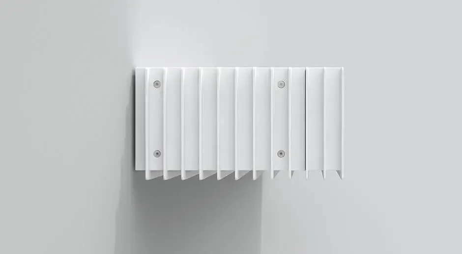 A white radiator with vertical panels mounted on a plain white wall.