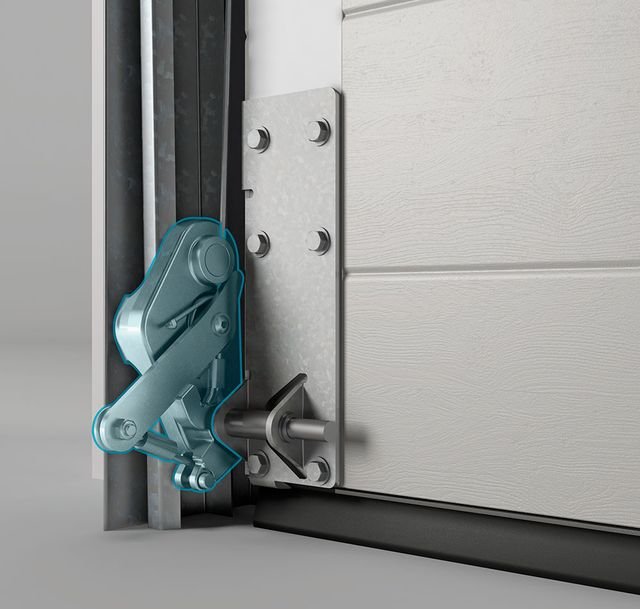 Close-up of a garage door opener mechanism showing a metallic latch connected to a door track and garage door with a white exterior panel.
