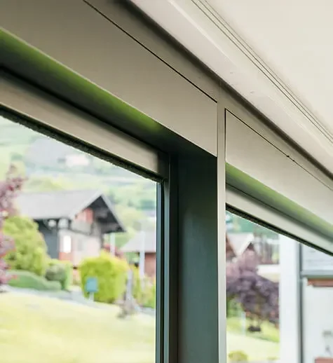 Close-up of a window frame with a view of a suburban neighborhood with houses and trees outside.