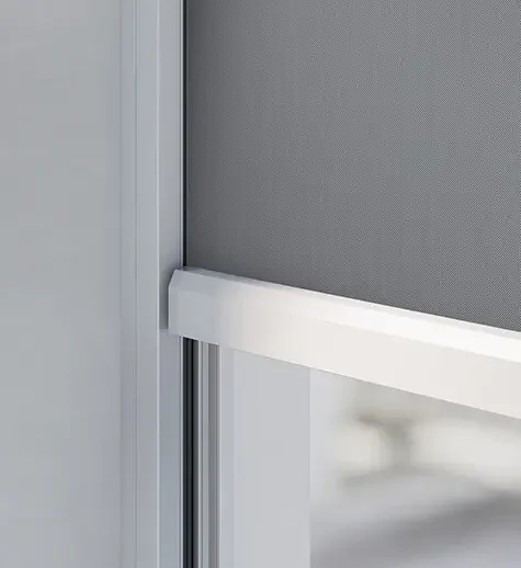 Close-up of a glass door with a white frame and a metal screen or panel on the upper part.