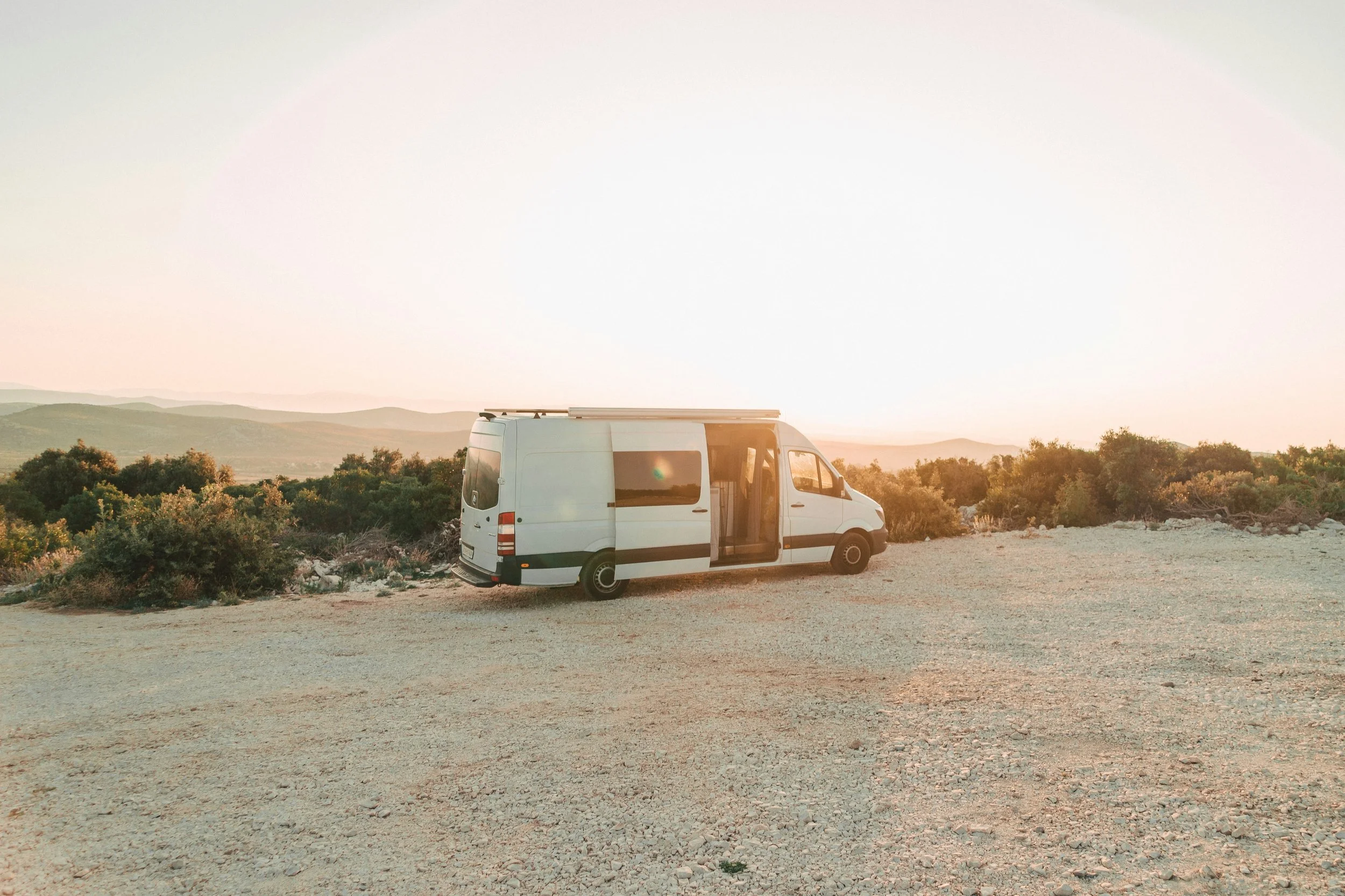 Van aménagé en Bulgarie au coucher du soleil, voyage nomade et liberté totale