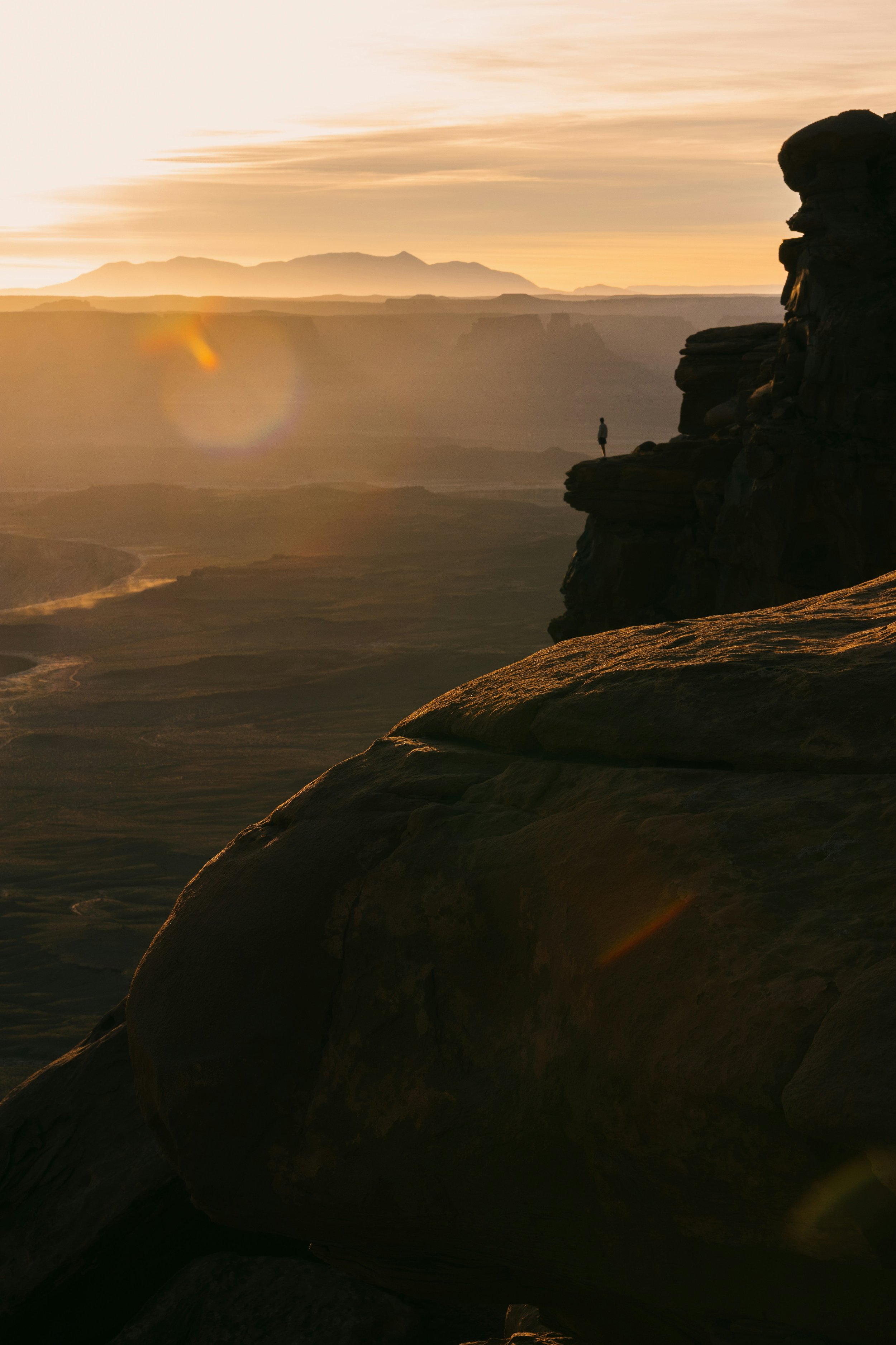 Coucher de soleil sur un canyon avec une silhouette humaine debout sur une falaise