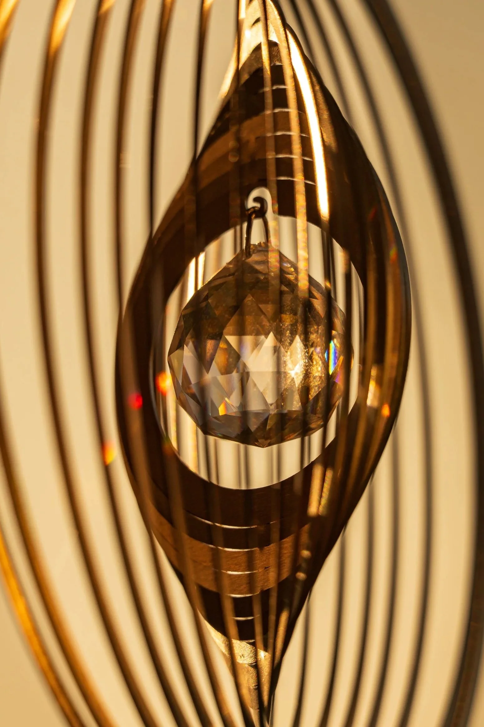 Nahaufnahme eines Kristalls in einer Kristall-Leuchte, umgeben von goldfarbenen Spiralen.