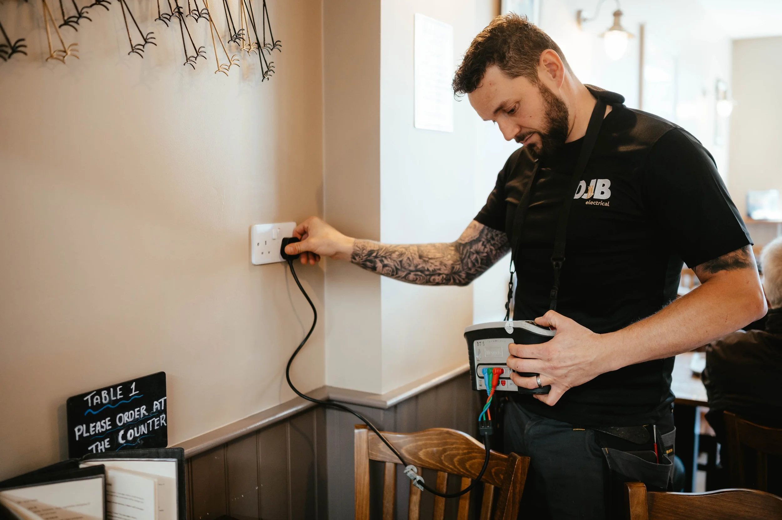 Electrician plugging in an electrical outlet in a restaurant or cafe.