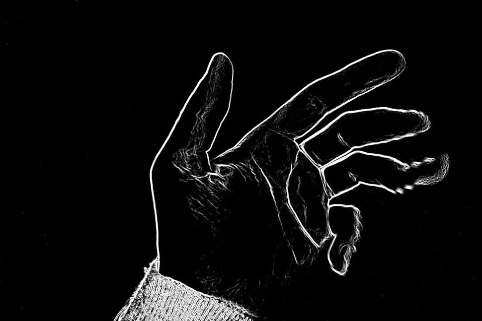 A high-contrast, stylized outline of a human hand with fingers slightly curled, wearing a knit sleeve, against a black background.