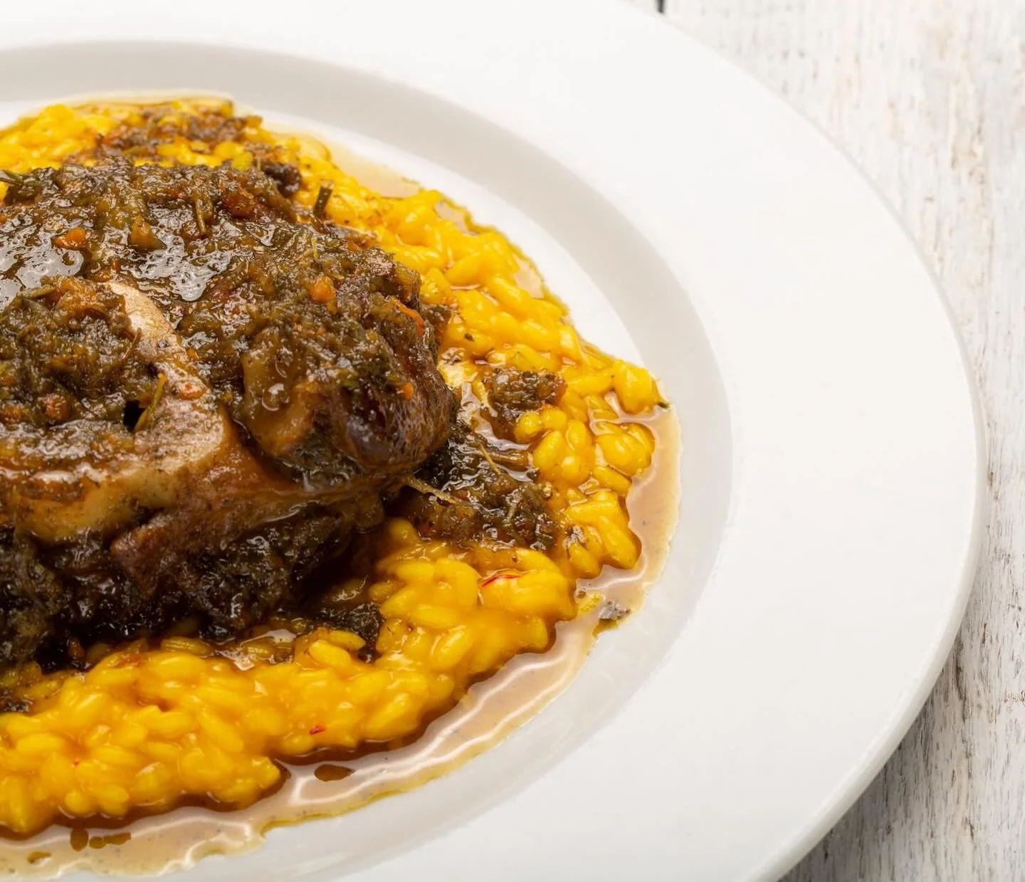 Risotto alla milanese preparato secondo la ricetta tradizionale con ossobuco alla milanese e la sua gremolada.
