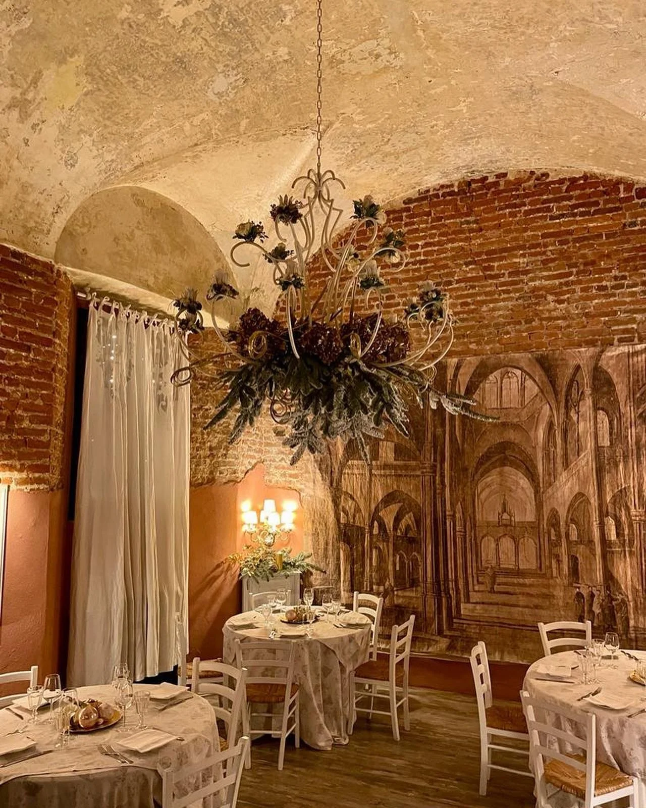 Sala interna suggestiva dell’Osteria del Ponte in un antico castello medievale, con muri in mattoni
