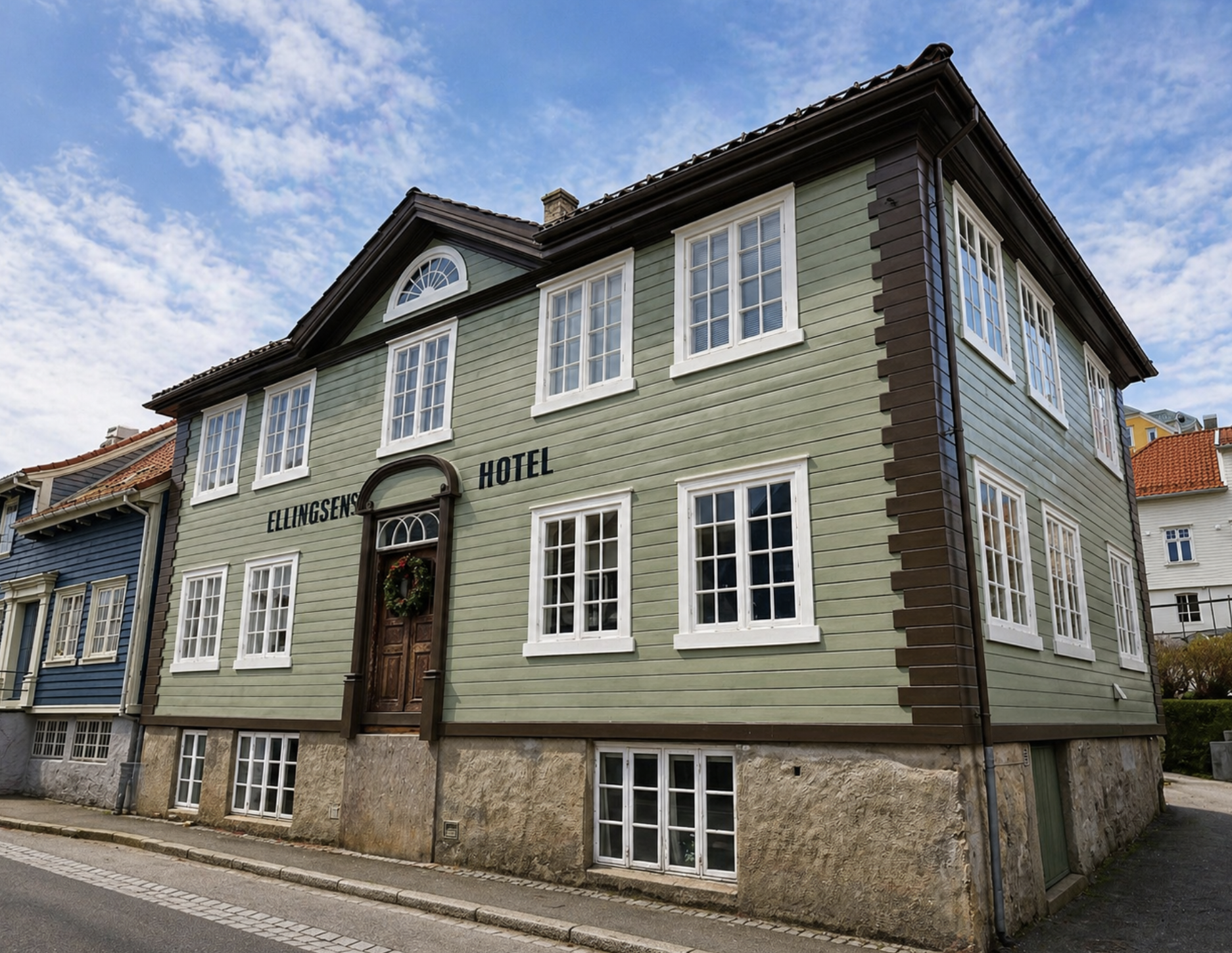 Moderne hus med store vinduer, omgitt av fjell og lavtvoksende vegetasjon på landsbygda.
