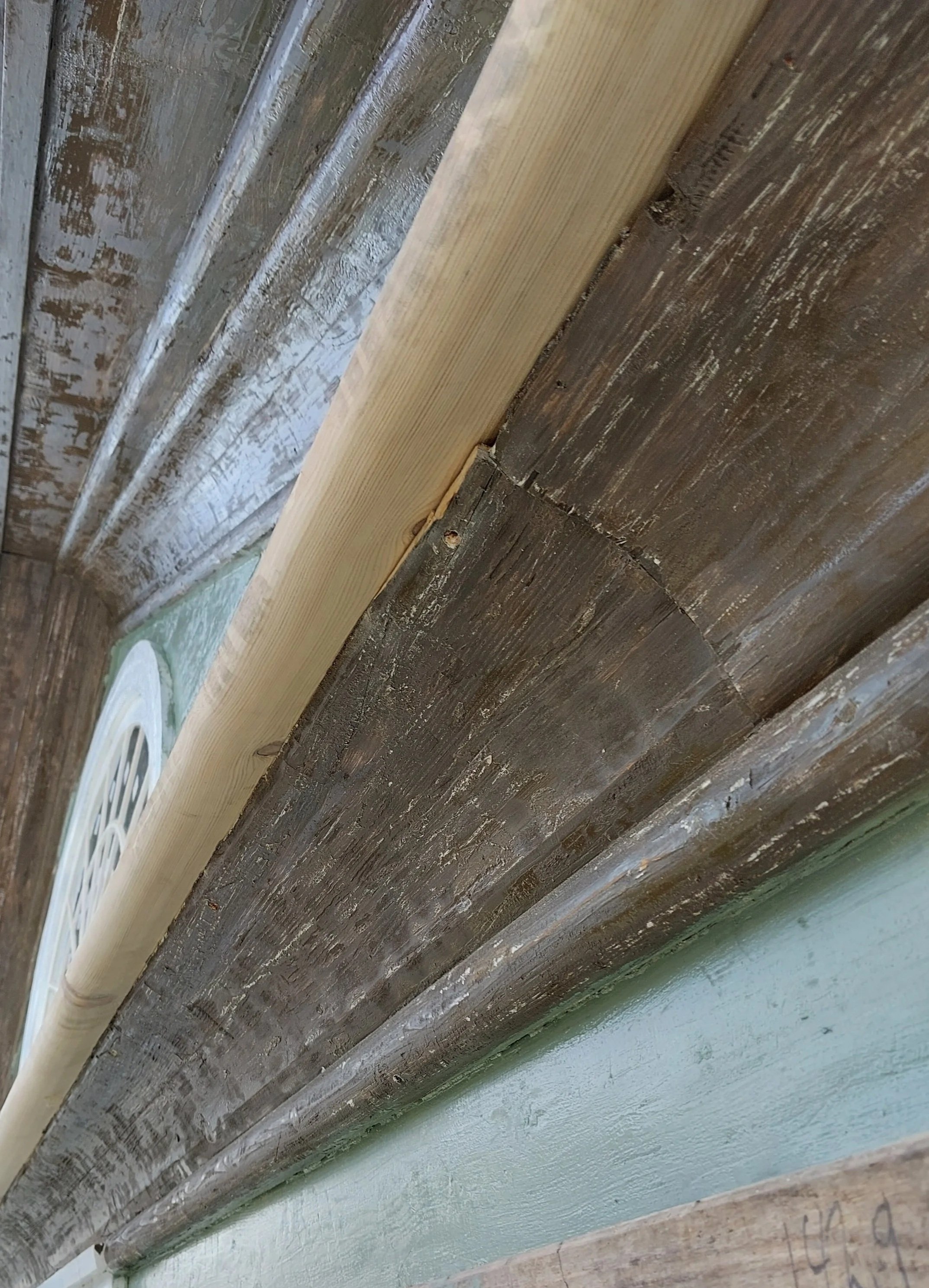 vedlikeholdsarbeid, nærbilde av treverk, med en lys furu- og en mørkebrun panel, som er montert på en vegg.