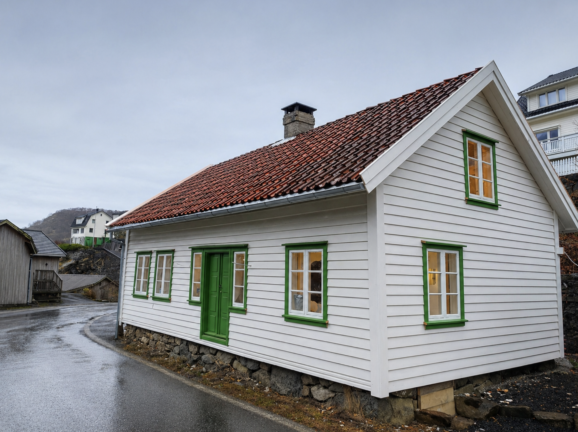Bilde av fjell med snø på toppene, grønne åser nederst, og en moderne bygning på en av åsene.